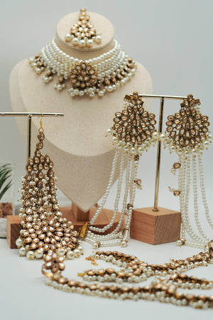 Jewelry set including necklace, earrings, and a headpiece on a mannequin and wooden stands.
