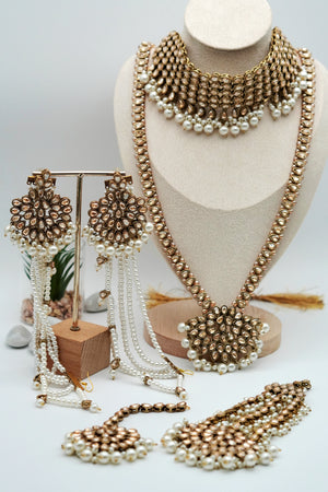 Set of gold and pearl jewelry on a mannequin and stand against a light background