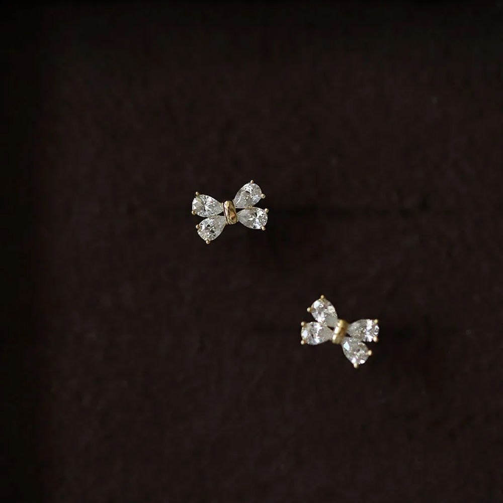 Pair of butterfly-shaped diamond earrings on a dark background