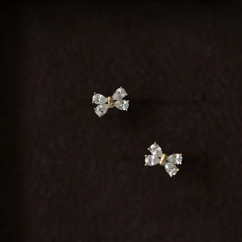 Pair of butterfly-shaped diamond earrings on a dark background